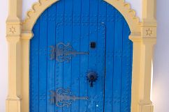 Ornate Archway and Blue Door Tunisia Street Scene Product Image 4