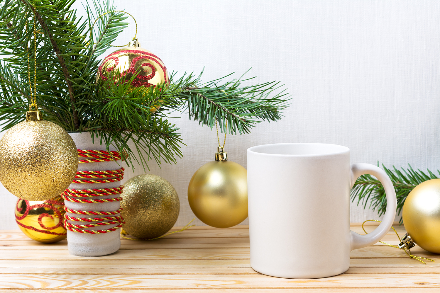 White coffee mug mockup with golden Christmas ornaments