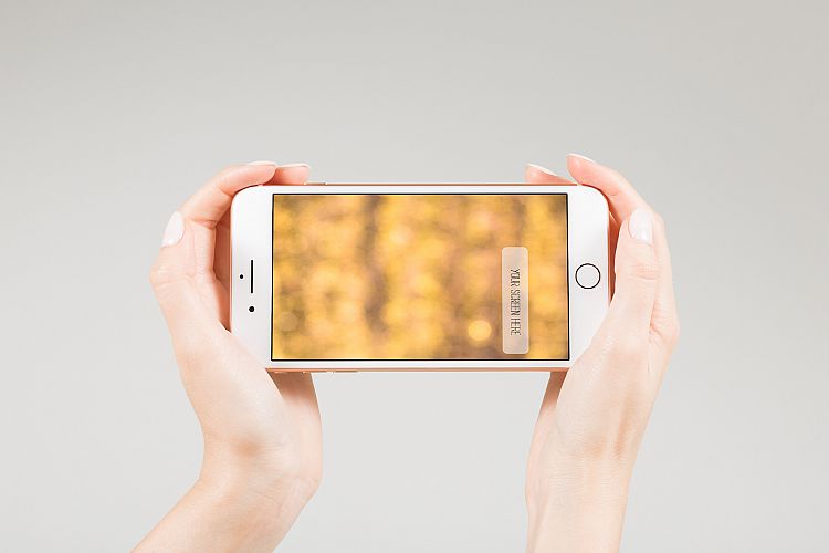 Female holding smartphone with blank screen in two hands