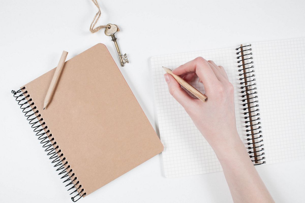 Writing in notebook on white table example image 1