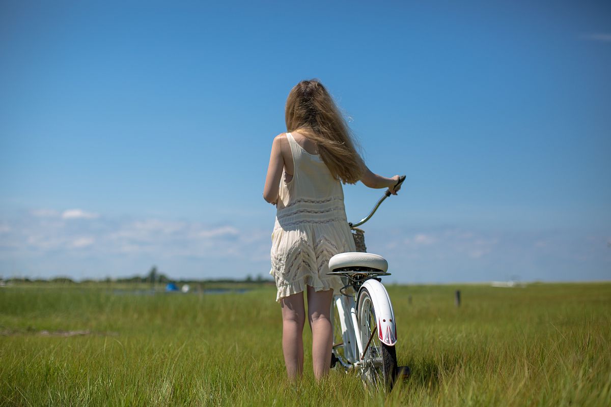 Women with a bike on the green field example image 1