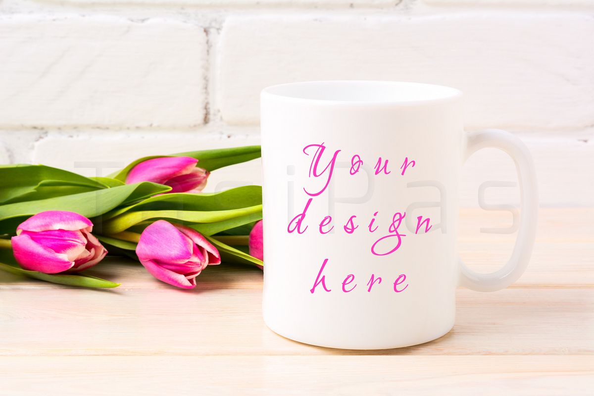 White coffee mug mockup with rich magenta pink tulips bouquet near painted brick wall. example image 1
