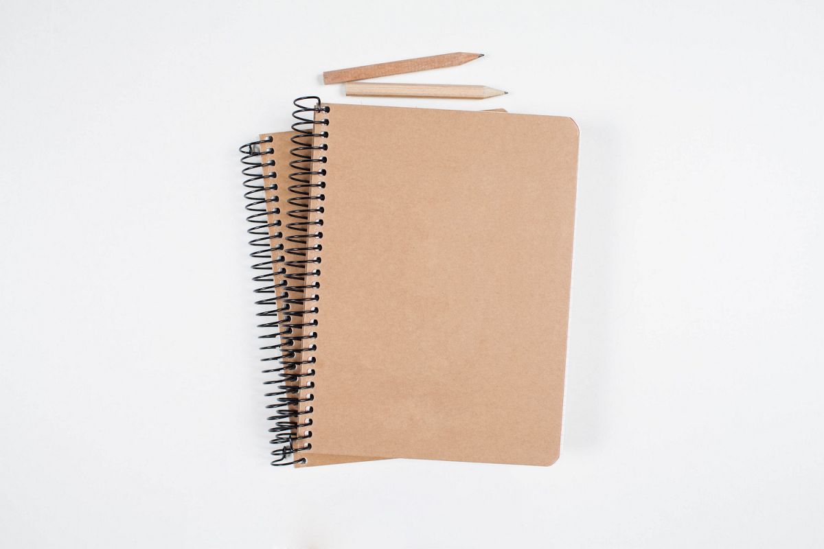 Old notebooks and pencils on white table example image 1