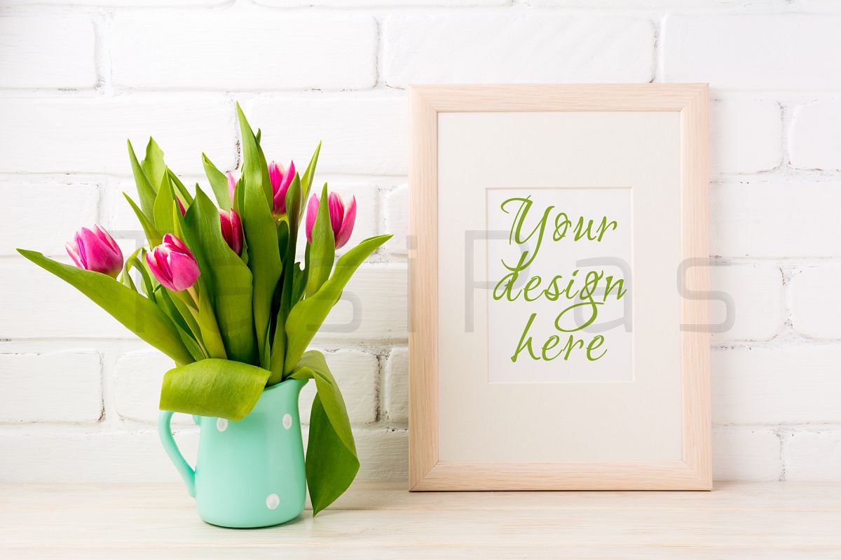 Wooden frame mockup with bright pink tulips bouquet in mint jug near white painted brick wall. example image 1
