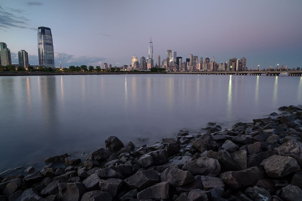 Rock beach view on downtown Manhattan and Jersey city during twilight example image 1