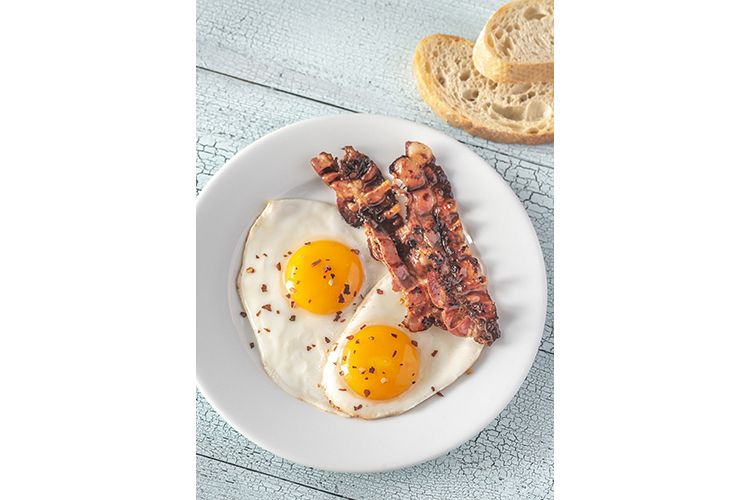 Fried eggs and bacon on the white plate example image 1