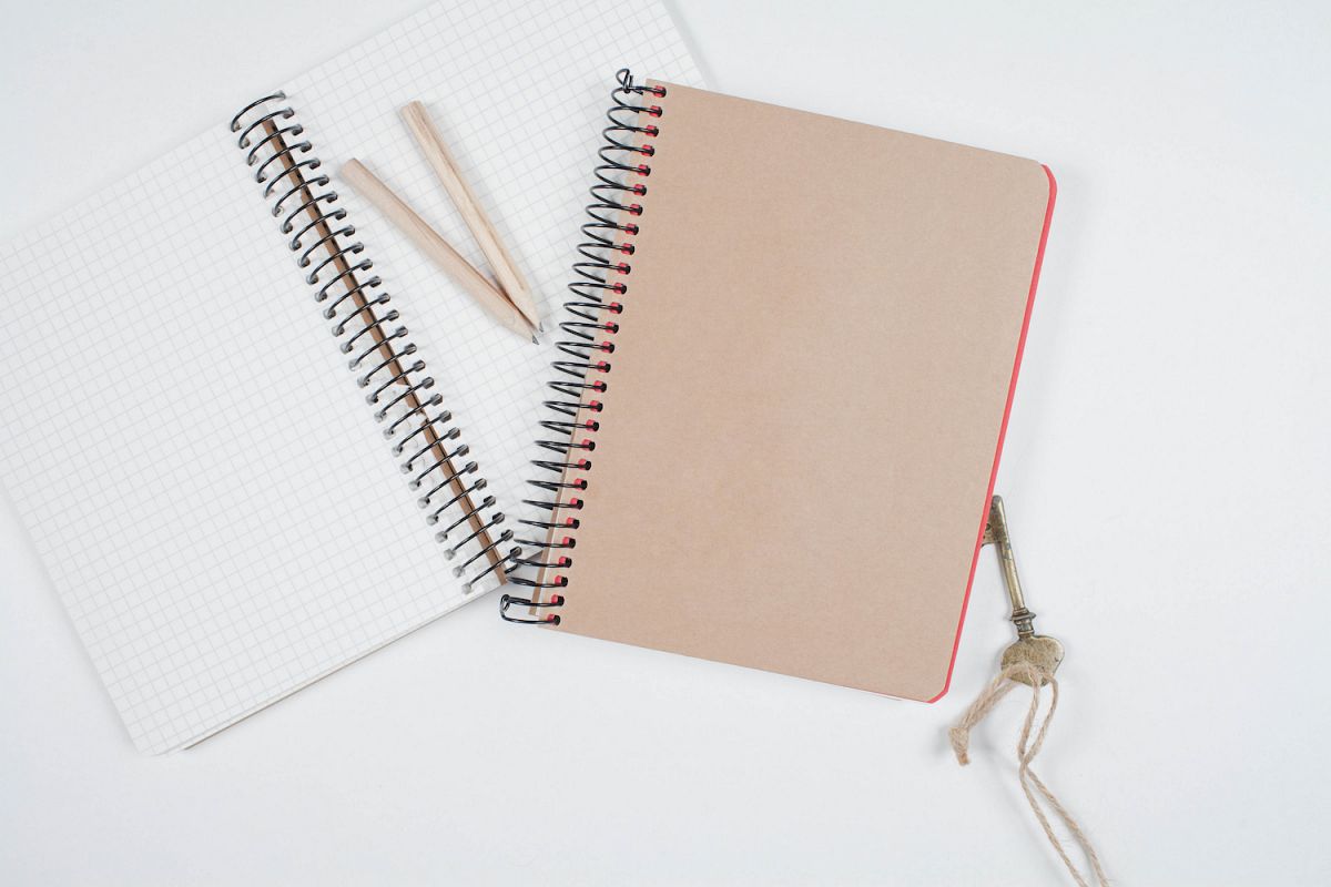 Old notebooks and pencils, key on white table example image 1