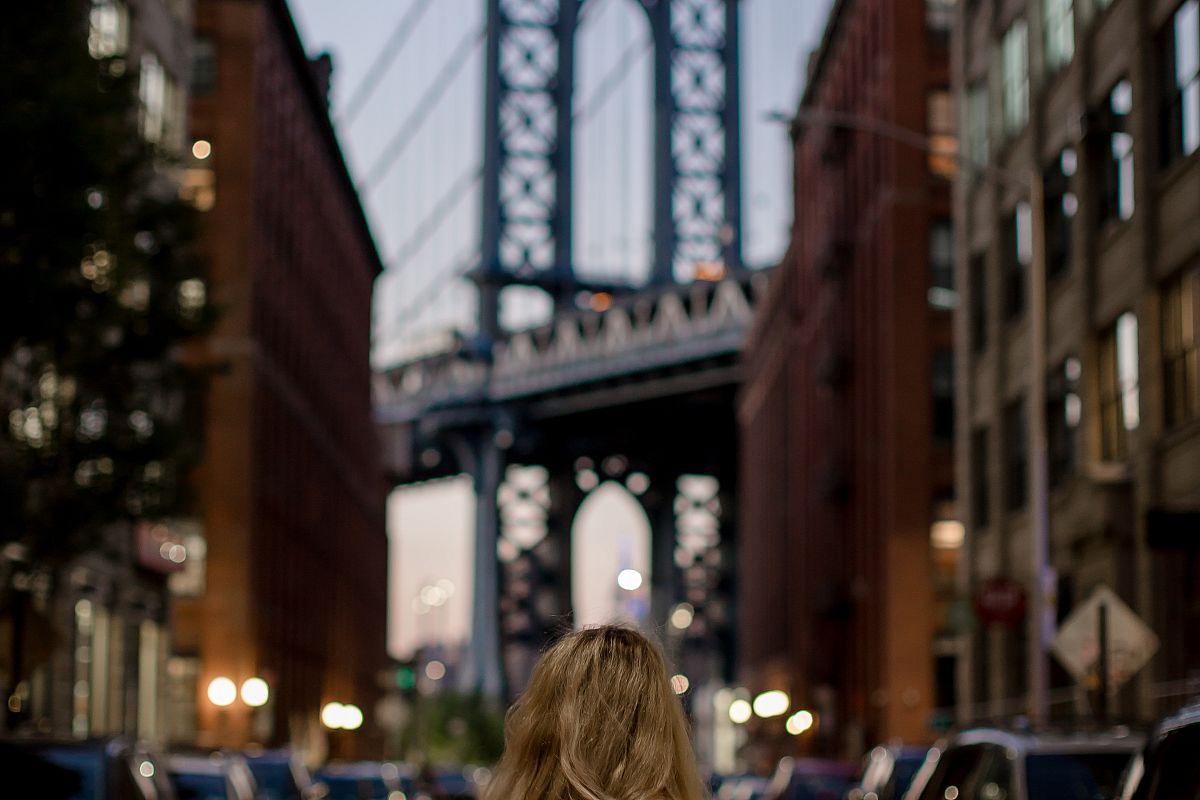 Lady standing on old street, looking at manhattan bridge example image 1
