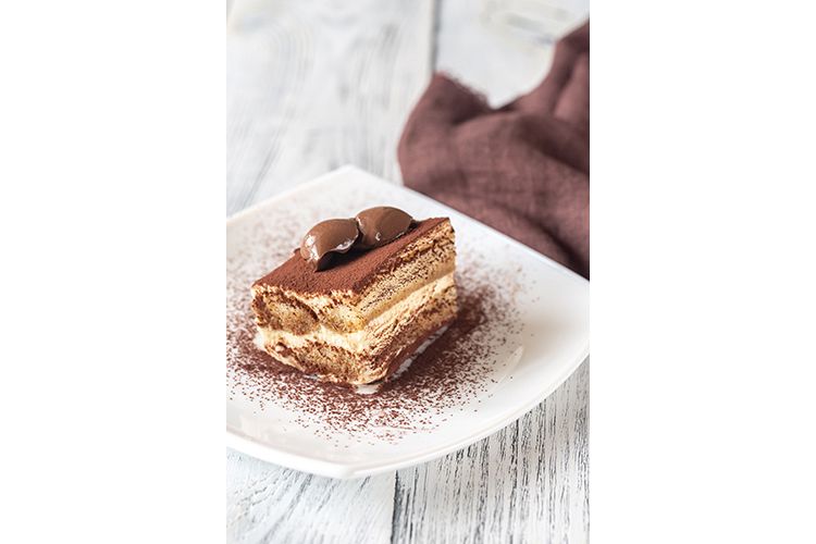 Portion of tiramisu on the white plate example image 1