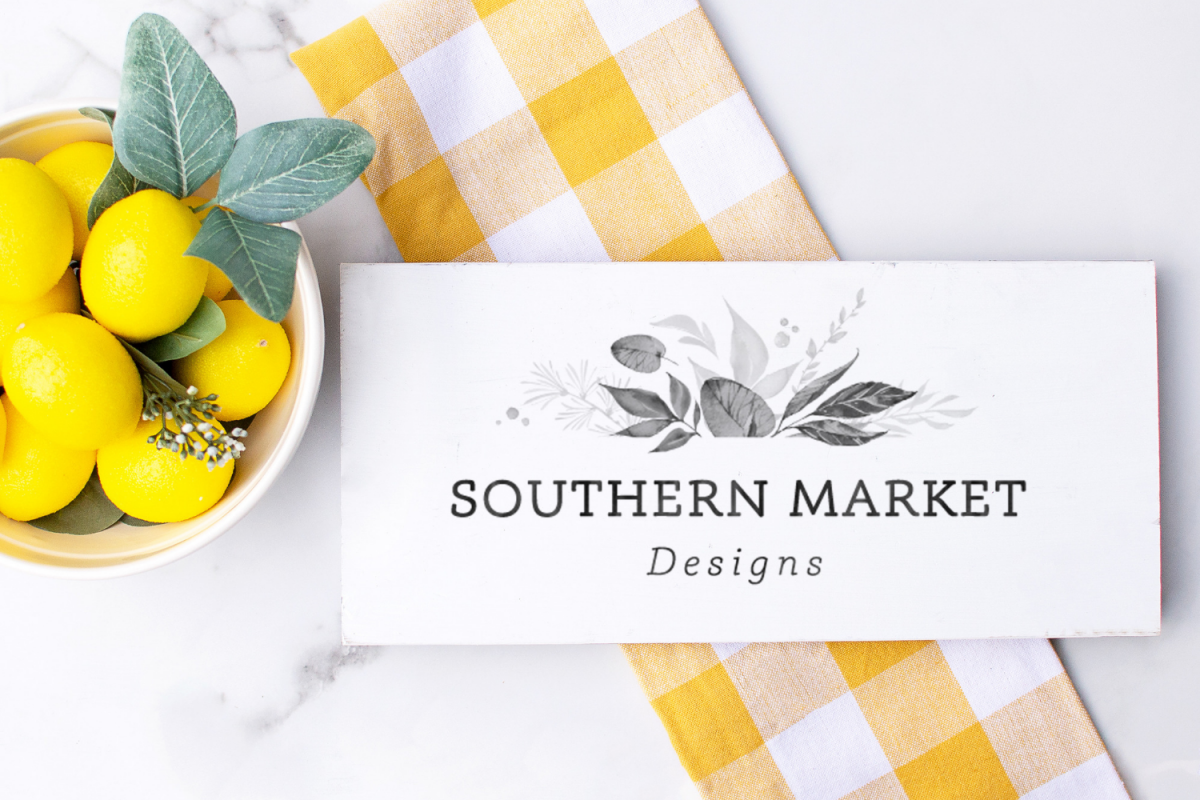 Wood sign mockup showing a wood sign design in a kitchen with lemons and a yellow checkered tea towel.