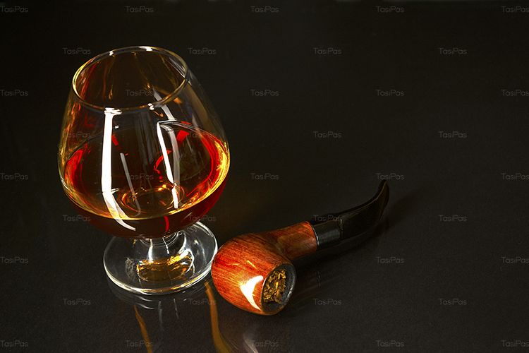 Whiskey glass and smoking pipe on black background example image 1