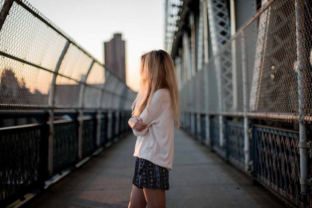 Girl standing on a bridge at sunset example image 1