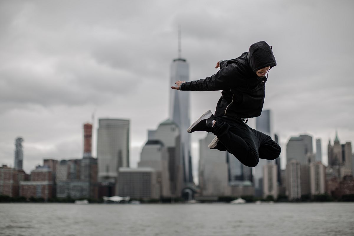 Man jumping on the front of downtown manhattan view example image 1