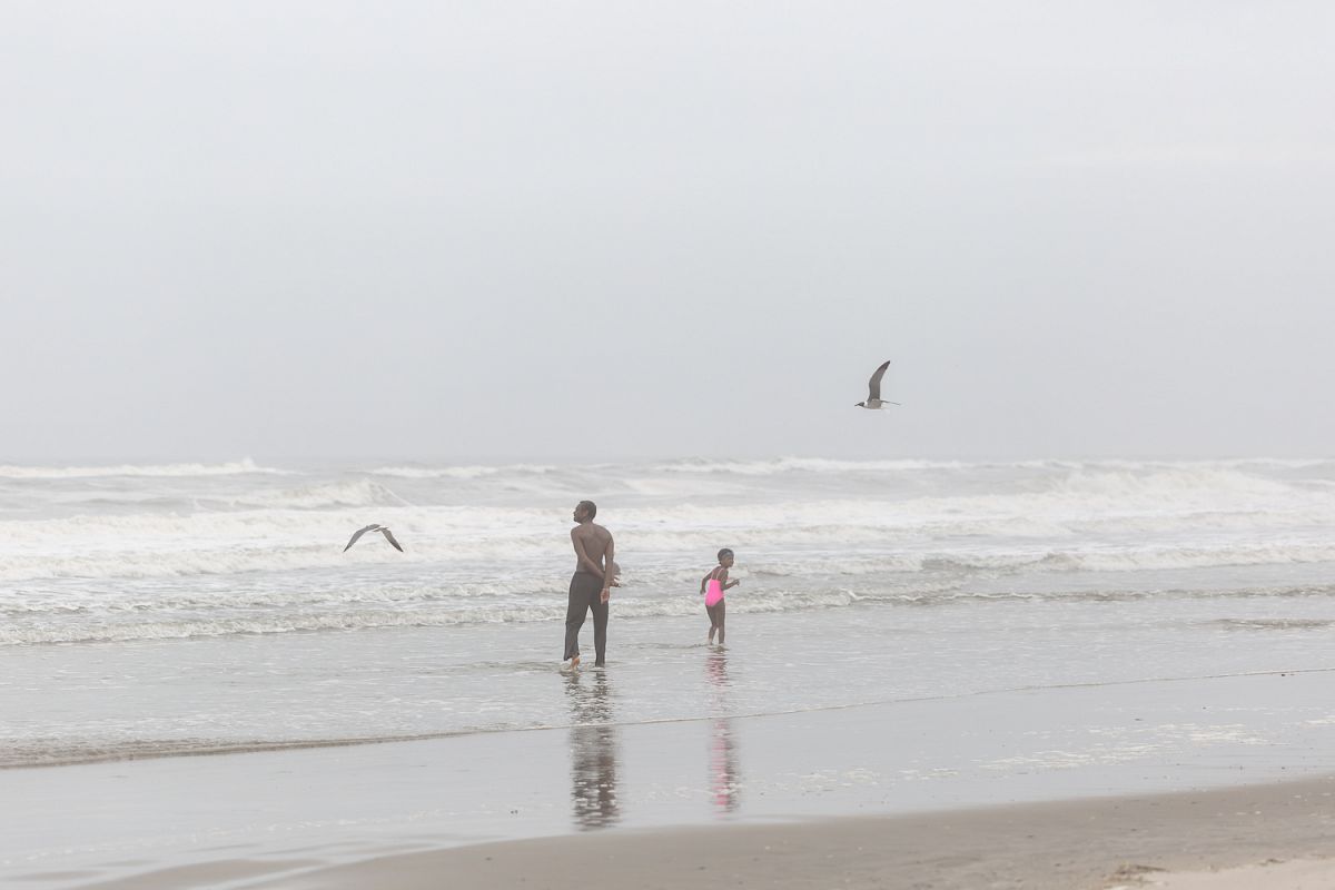 Man with child in the ocean on a foggy day example image 1