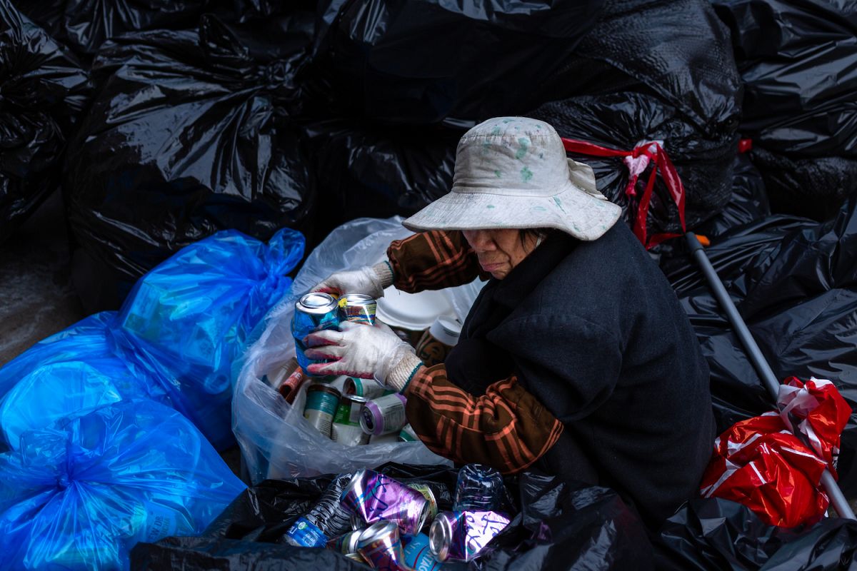 Chinese older woman collecting cans from trash example image 1