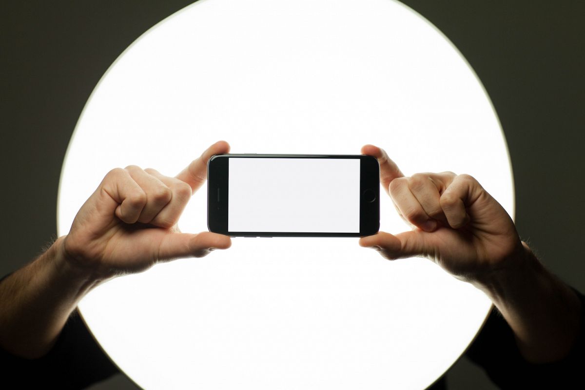 Two hands holding smartphone with blank screen example image 1