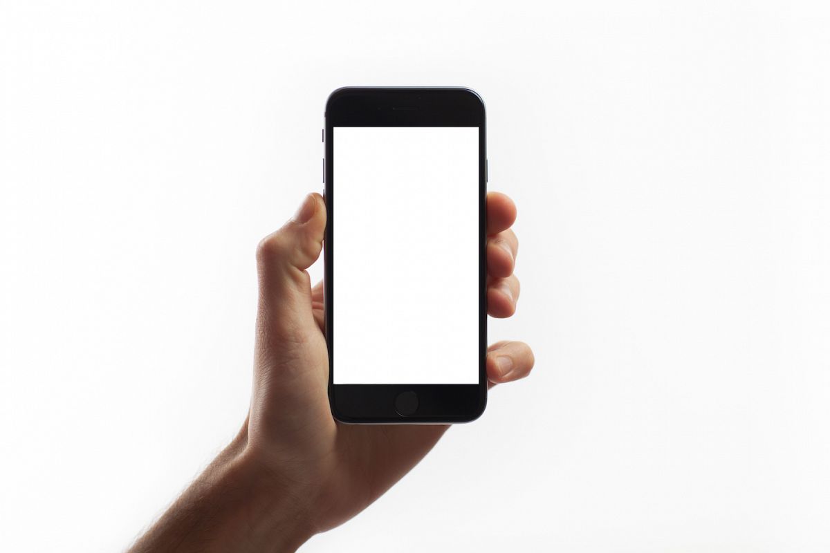 Hand holding mobile smart phone with blank screen example image 1