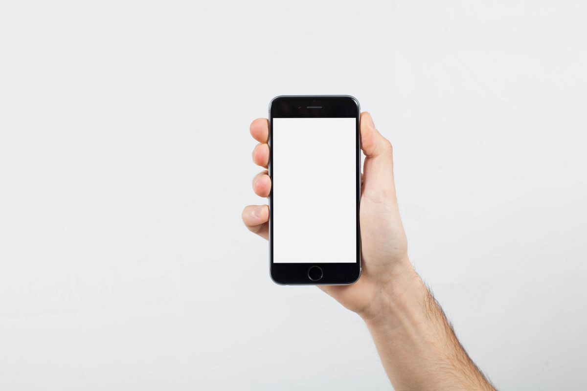 Male Hand holding mobile smart phone with blank screen example image 1