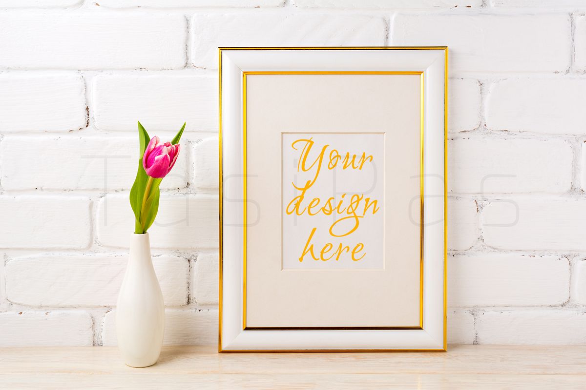 Gold decorated frame mockup with rich magenta pink tulip in elegant vase near white painted brick wall. example image 1
