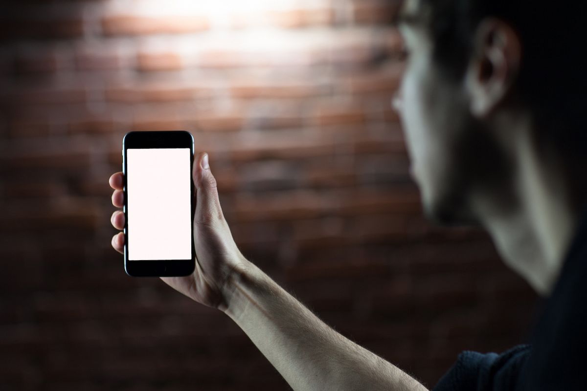 Young man holding mobile smart phone with blank screen example image 1