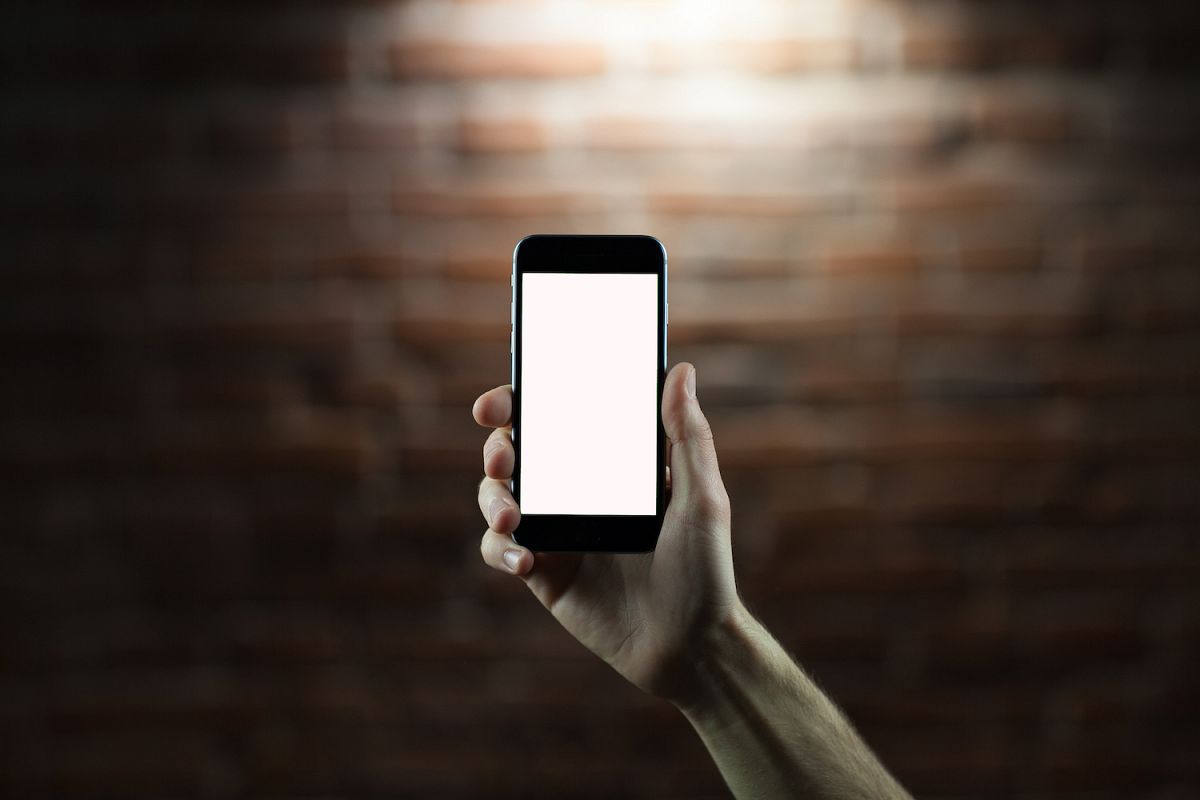Hand holding mobile smart phone with blank screen example image 1