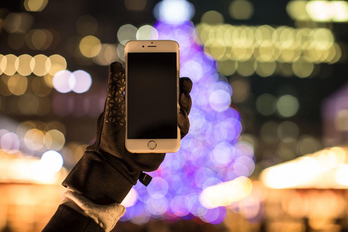 Winter hand holding smartphone with blank screen example image 1